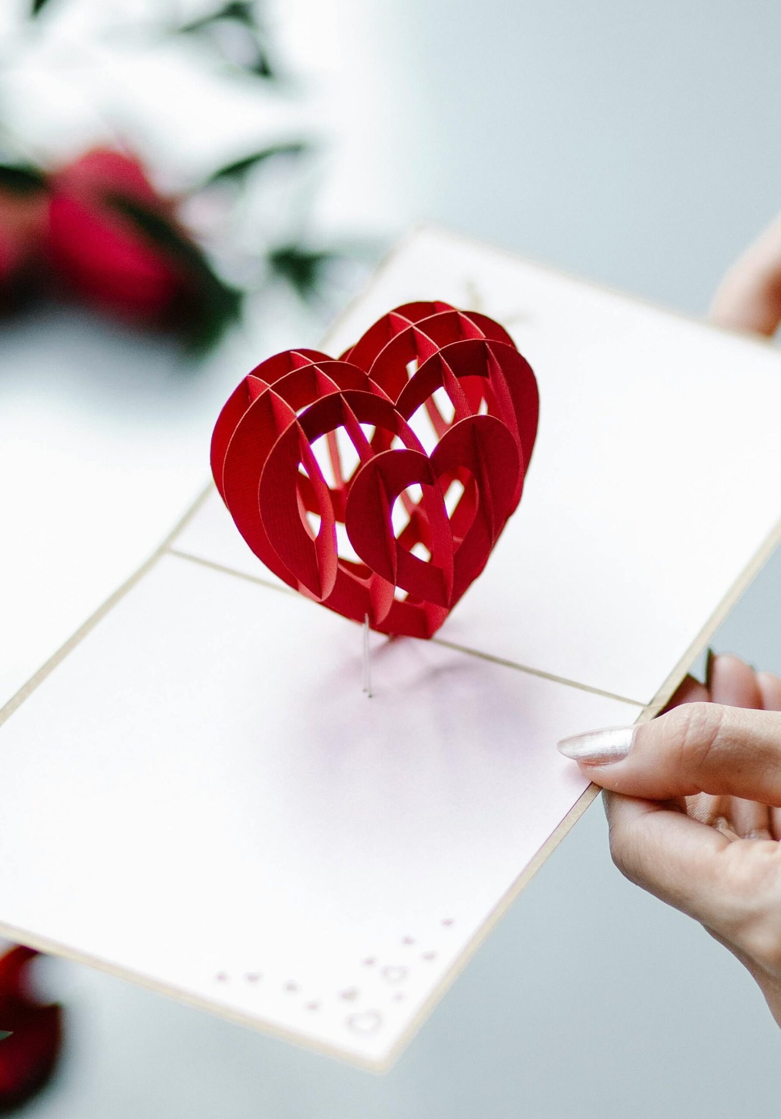 Elegant red heart pop-up card held by a woman, perfect for Valentine